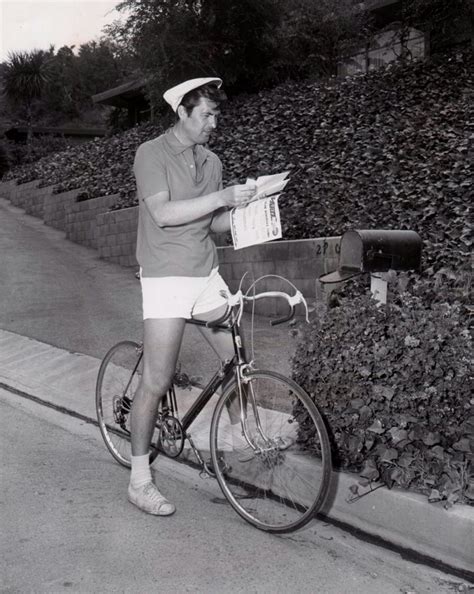 Fess Parker rides a bike, reads his mail.