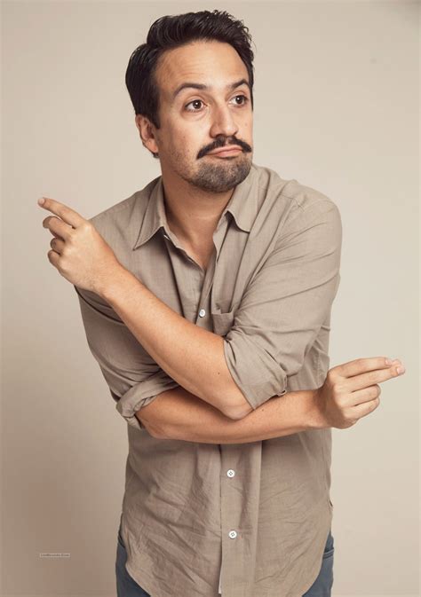 a man with a mustache is posing for the camera while holding his arms crossed out