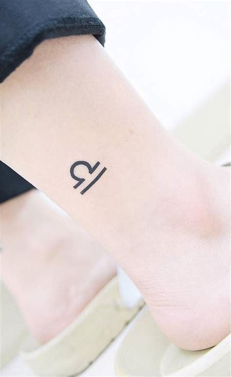 Libra Zodiac symbol tattoo on the right ankle.