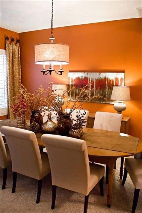 a dining room with orange walls and white chairs