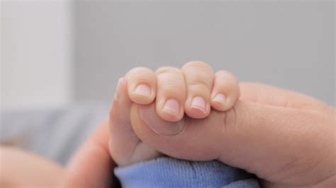 Premium Photo | Parents hands holding newborn babys fingers close up of ...