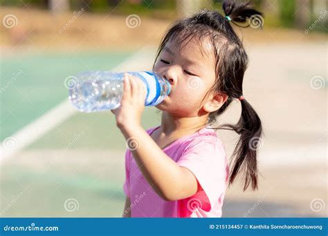 Asian Child are Drinking Some Water from Plastic Bottles. Cute Girl ...