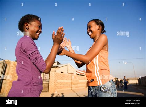 Two girls clapping hands, smiling, side view Stock Photo - Alamy