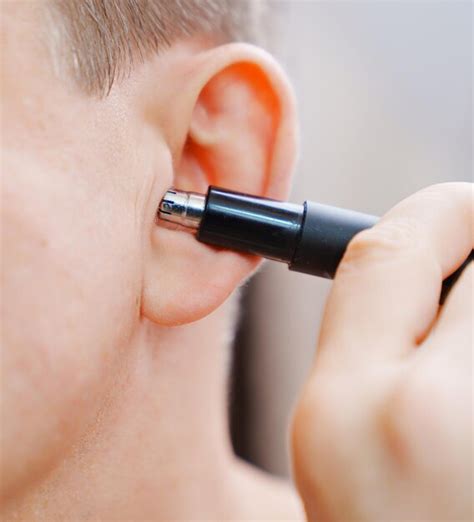 Premium Photo | Closeup a man cuts his ear hair with a trimmer