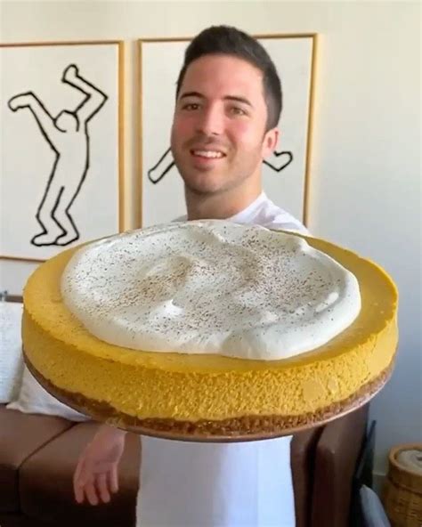 a man holding up a cake with frosting on it