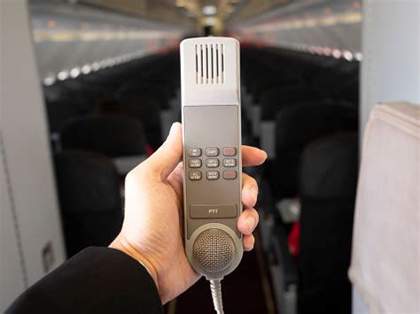 Male Cabin Crew Holding Interphone In Aircraft Cabin Stock Photo ...