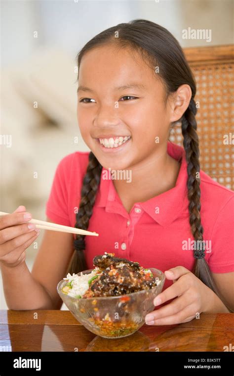 Young girl in dining room eating chinese food smiling Stock Photo - Alamy