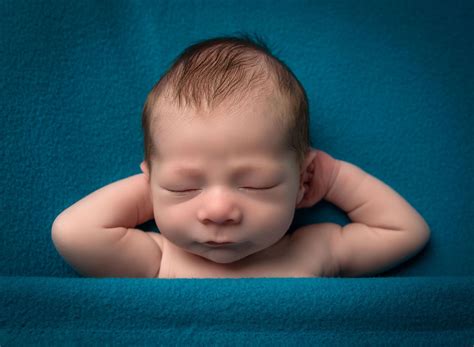 newborn baby boy sleeping with his hands tucked behind his head on dark teal blanket | Baby boy ...