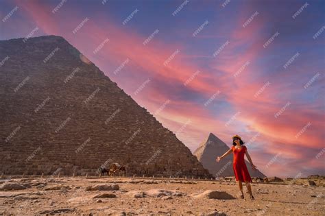 Premium Photo | A young girl in a red dress at the pyramid of cheops the largest pyramid at ...