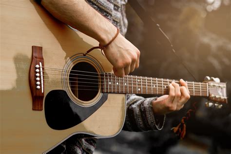 Young musician playing acoustic guitar close up - Oxford Athletic Club