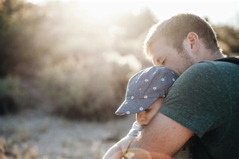 Man Hugging the Baby in Blue Floral Fitted Cap during Daytime · Free Stock Photo