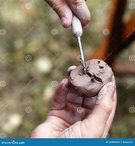 A Child is Shaping Brown Clay Using Specialty Tools in a Workshop during an Art Festival in ...