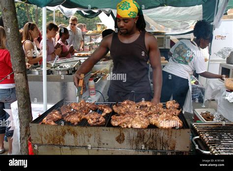 Grilling barbequing Jerk chicken outside on stall during Notting Hill Carnival Stock Photo - Alamy