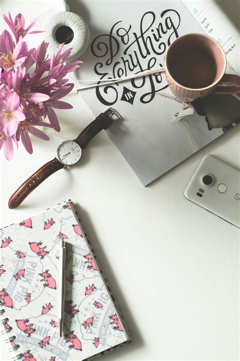 Personal organizer and pink flowers on desk · Free Stock Photo
