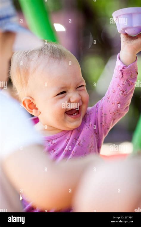 Laughing little baby playing with a toy Stock Photo - Alamy