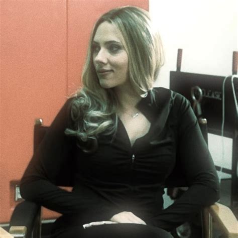 a woman sitting in a chair with her legs crossed and looking off to the side