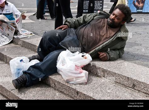 homeless black man in dirty clothing relaxes peacefully sunwarmed by Stock Photo: 24604384 - Alamy