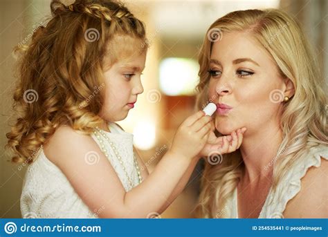 And Some Lipstick for the Queen Too...a Little Girl Applying Lipstick To Her Mother at Home ...