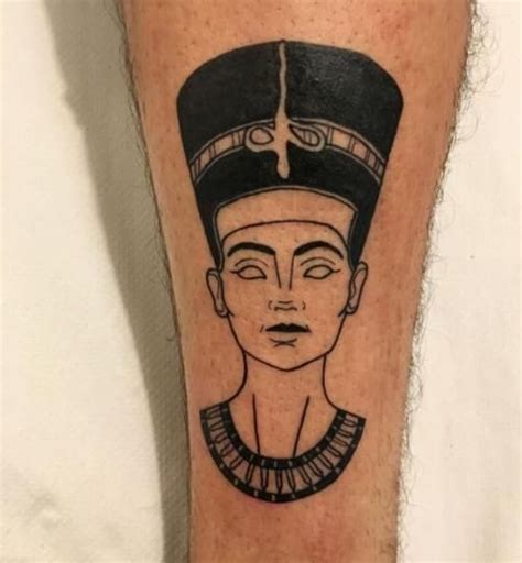 a man's leg with an egyptian tattoo design on his left calf and head
