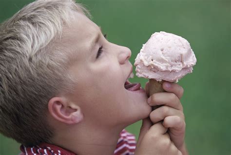 Side profile of a boy eating an ice cream cone - Maren Schmidt