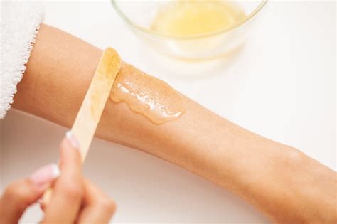 Premium Photo | Skin care, a woman applies wax to her hand to remove hair