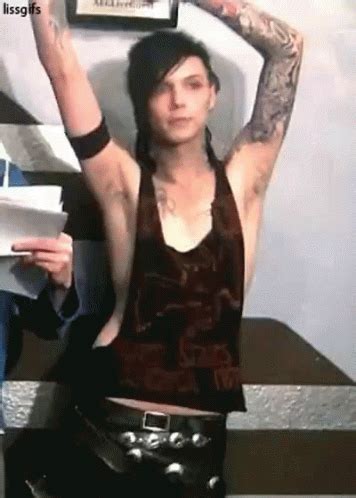 a woman with tattoos holding her arms up in the air