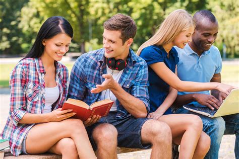 We love spending time together. Four happy young people spending time together while sitting ...