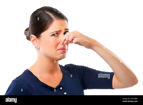 Gross. Studio shot of a young woman holding her nose isolated on white ...