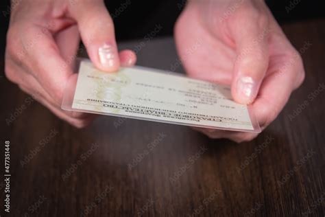 An older woman (old lady) holds in her hand an insurance certificate of compulsory pension ...