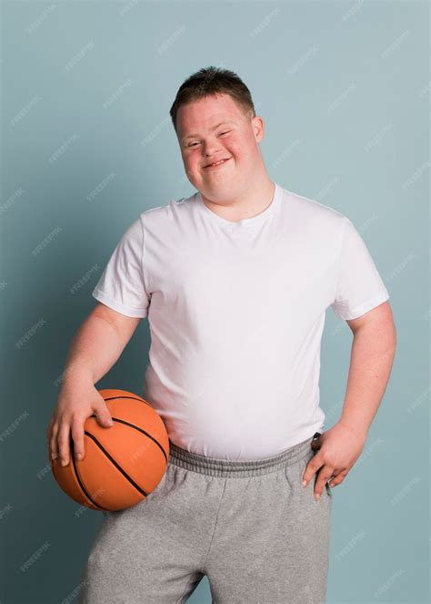 Premium Photo | Cute athletic boy with down syndrome holding a basketball