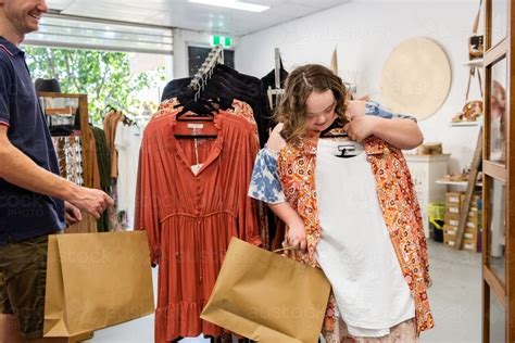 Image of Happy young lady with down syndrome shopping in dress and clothing store boutique ...