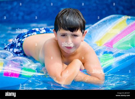 Happy young boy with inflatable water lounger in the swimming pool Stock Photo - Alamy
