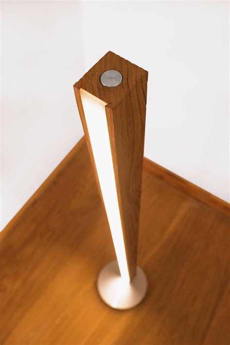 a wooden object with a white light on it's side in the middle of a wood floor