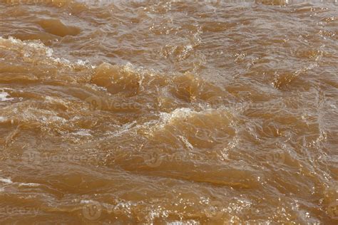 Muddy river water. Spring river with brown muddy water. Background ...