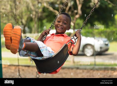 Small child swinging in the park smiling and having fun Stock Photo, Royalty Free Image ...