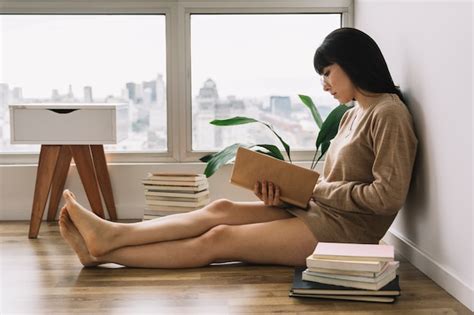 Free Photo | Barefoot female reading on floor