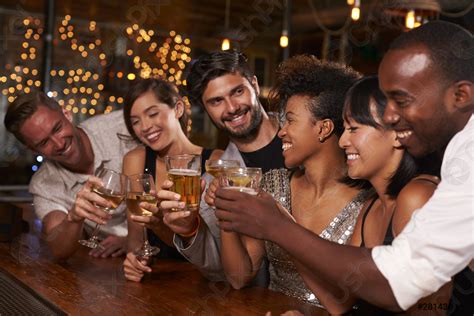 Jóvenes amigos adultos haciendo un brindis por el bar - foto de stock ...