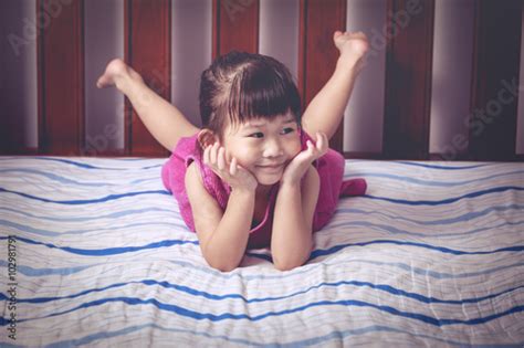 "Portrait of cute girl lying barefoot on bed in bedroom." Stockfotos und lizenzfreie Bilder auf ...