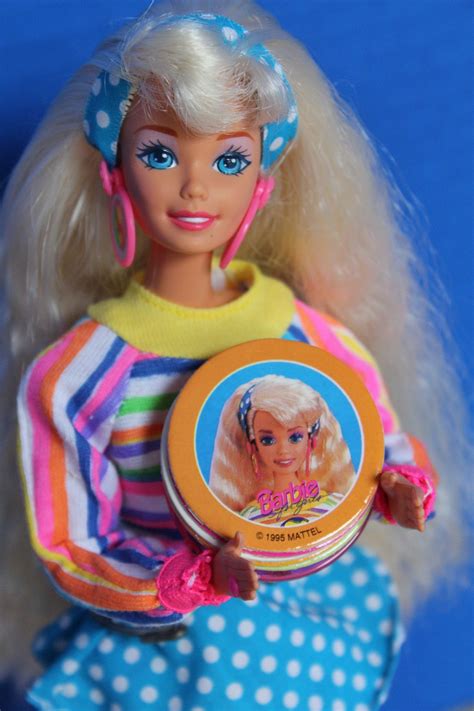a barbie doll holding a small round object