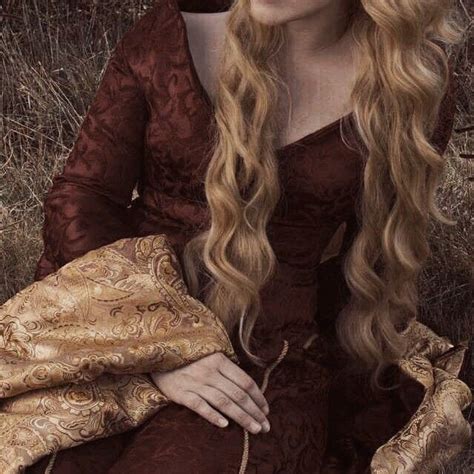 a woman with long blonde hair wearing a brown dress and holding a gold ...