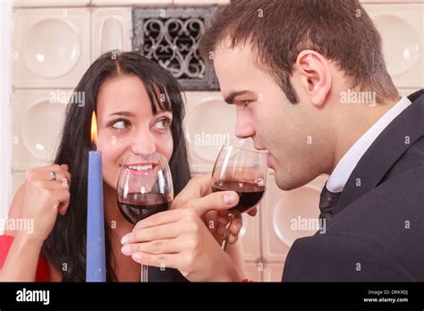 Romantic young couple toasting with red wine Stock Photo - Alamy