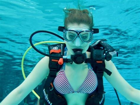 a woman wearing scuba gear and goggles in the water