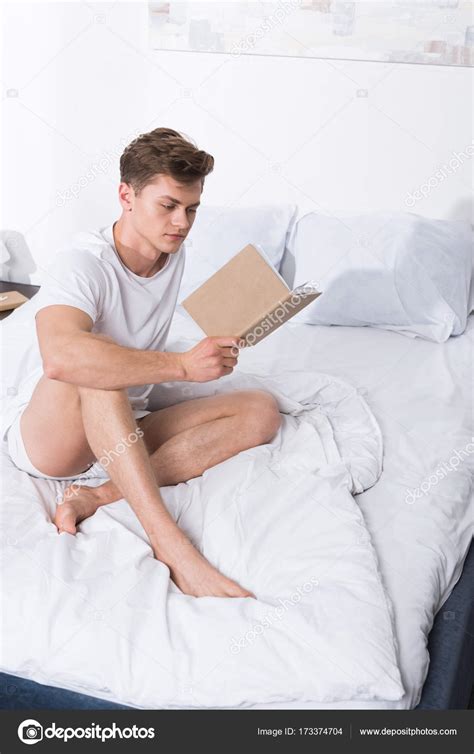 Man reading book in bed — Stock Photo © IgorVetushko #173374704