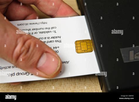 Man inserts a Smartcard security card into a laptop to provide extra security Stock Photo - Alamy