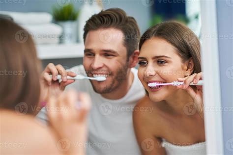 portrait d'un jeune couple heureux se brosser les dents dans la salle de bain 15770220 Photo de ...