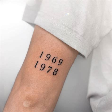 "1969" and "1978" lettering tattoo on the tricep.