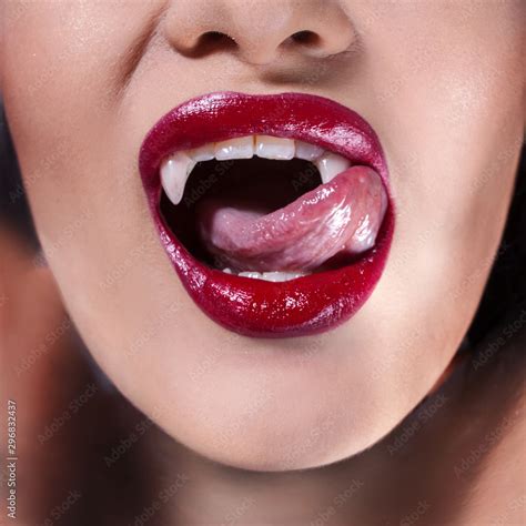 Sexy vampire. Women's lips with red lipstick. Tongue licking vampire ...