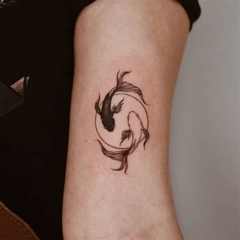 Yin yang koi fish tattoo located on the bicep.