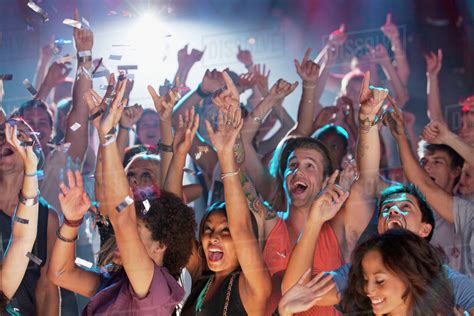 Enthusiastic crowd cheering at concert - Stock Photo - Dissolve