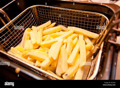 Cooking french fries in a deep fryer basket Stock Photo - Alamy